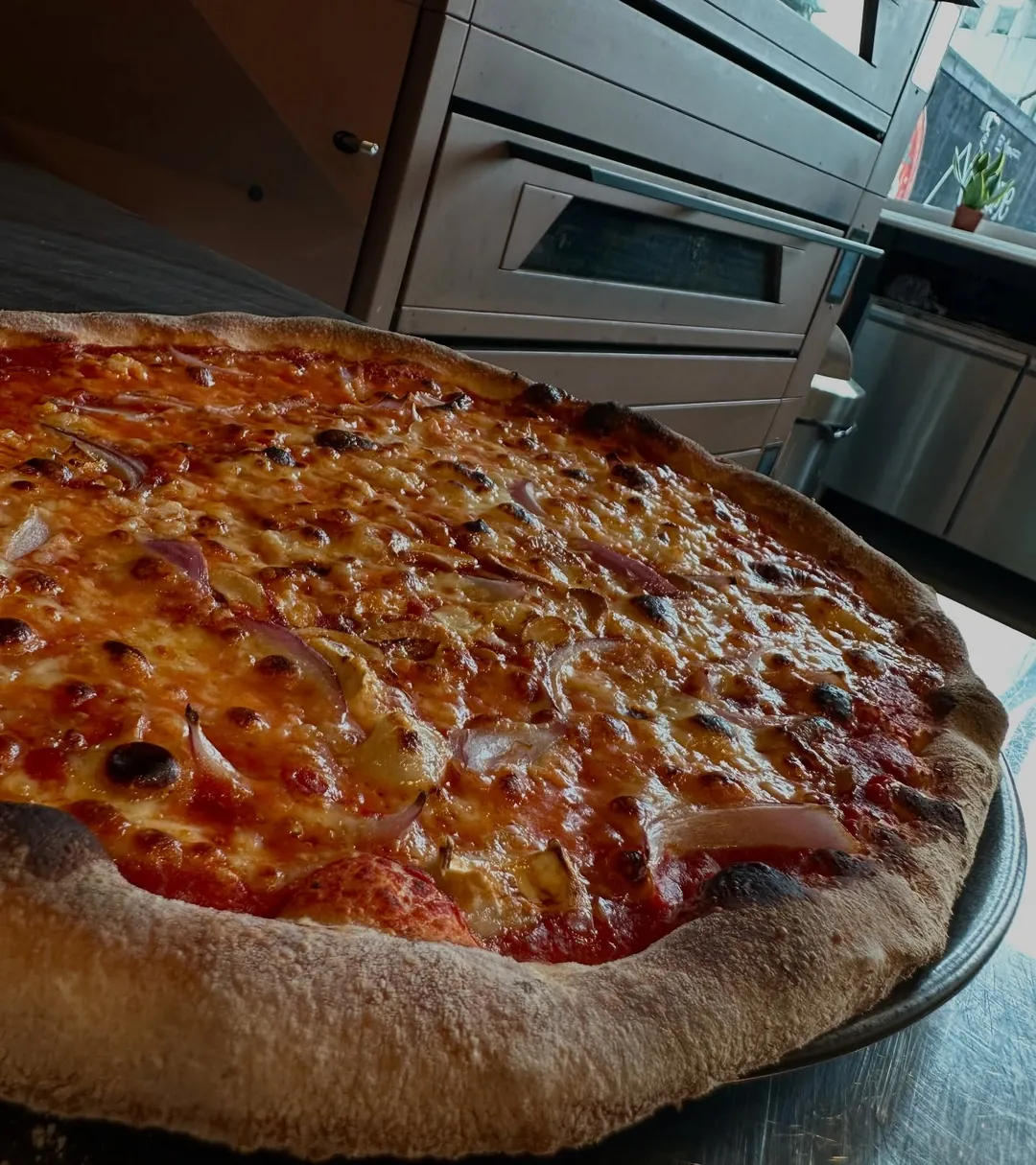 A pizza fresh from the oven, crisp and well done.